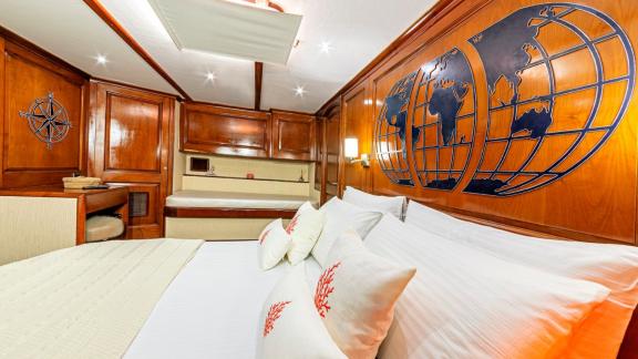 Luxurious cabin with large bed, sofa and stylish wood panelling.